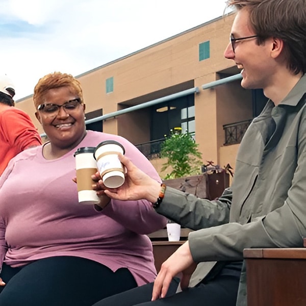 A man and women clink coffee cups