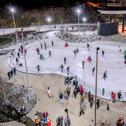 Tables and banners in a downtown plaza with people eating and conversing.