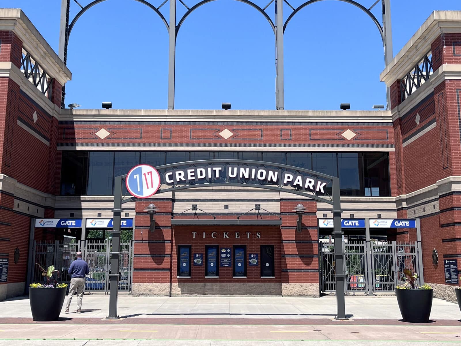 Photograph of the entry arch to 7 17 Credit Union Park in downtown Akron, Ohio. Beyond the arch are the ticket windows to the ballpark which is home to MLB AA Cleveland Guardians affiliate team, The Akron RubberDucks.